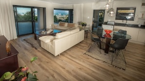 Ein modernes Wohnzimmer mit Sofa, Couchtisch und Essbereich.