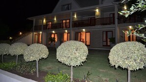 A two-story house with a balcony, a staircase, and a well-lit entrance. - Riverwalk B and B (Clarens)