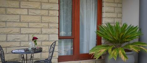A stone wall with a wooden door and a large potted plant.