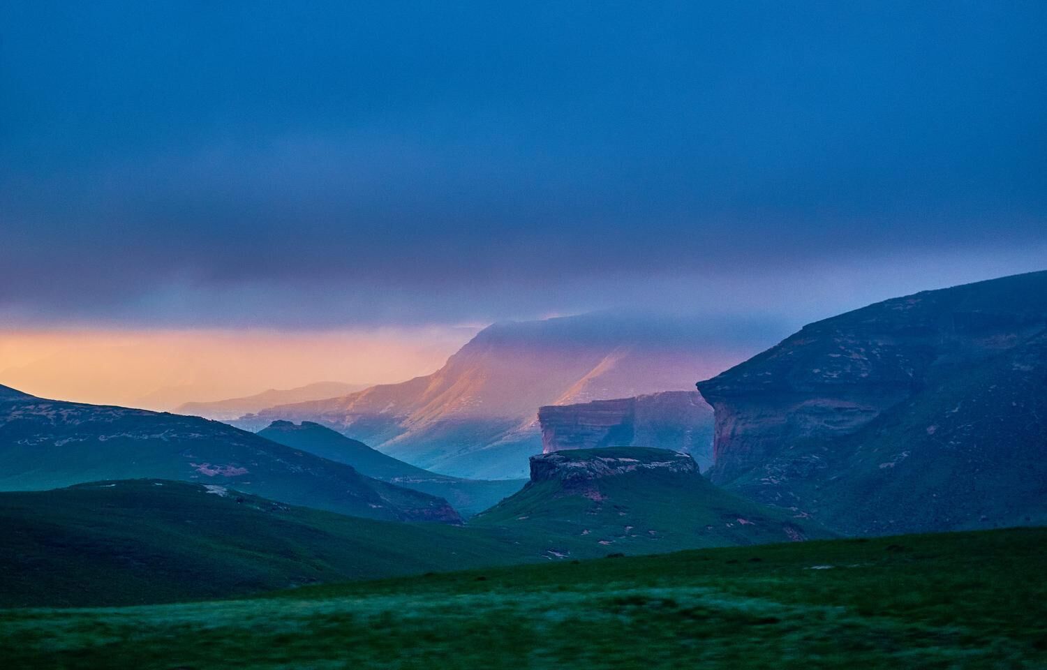 A mountainous landscape with a valley and cliffs.