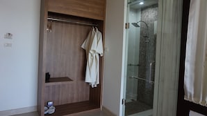 Un baño moderno con un mueble de tocador de madera, cabina de ducha de vidrio y perchero.
