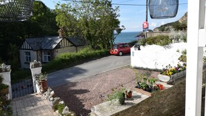 A paved pathway leading to a white building with a garden area. - Newberry Beach Lodge (Ilfracombe)
