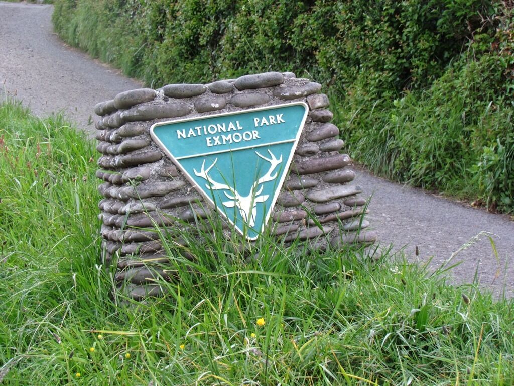 A sign for National Park Exmoor with deer symbols.