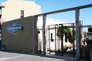 The entrance to the Lumsdens Hotel with a sign indicating it offers great food, a garden bar, and a cafe.