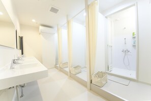 Een douche, pantoffels, een bidet, handdoeken