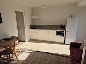 Eine kleine Küche mit Mikrowelle, Herd und Kühlschrank.