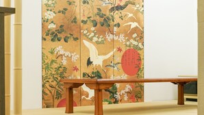 A traditional Japanese room with tatami flooring, a low wooden table, and a shoji screen with nature-themed artwork. - BONFIRE HOSTEL Osaka (Osaka)