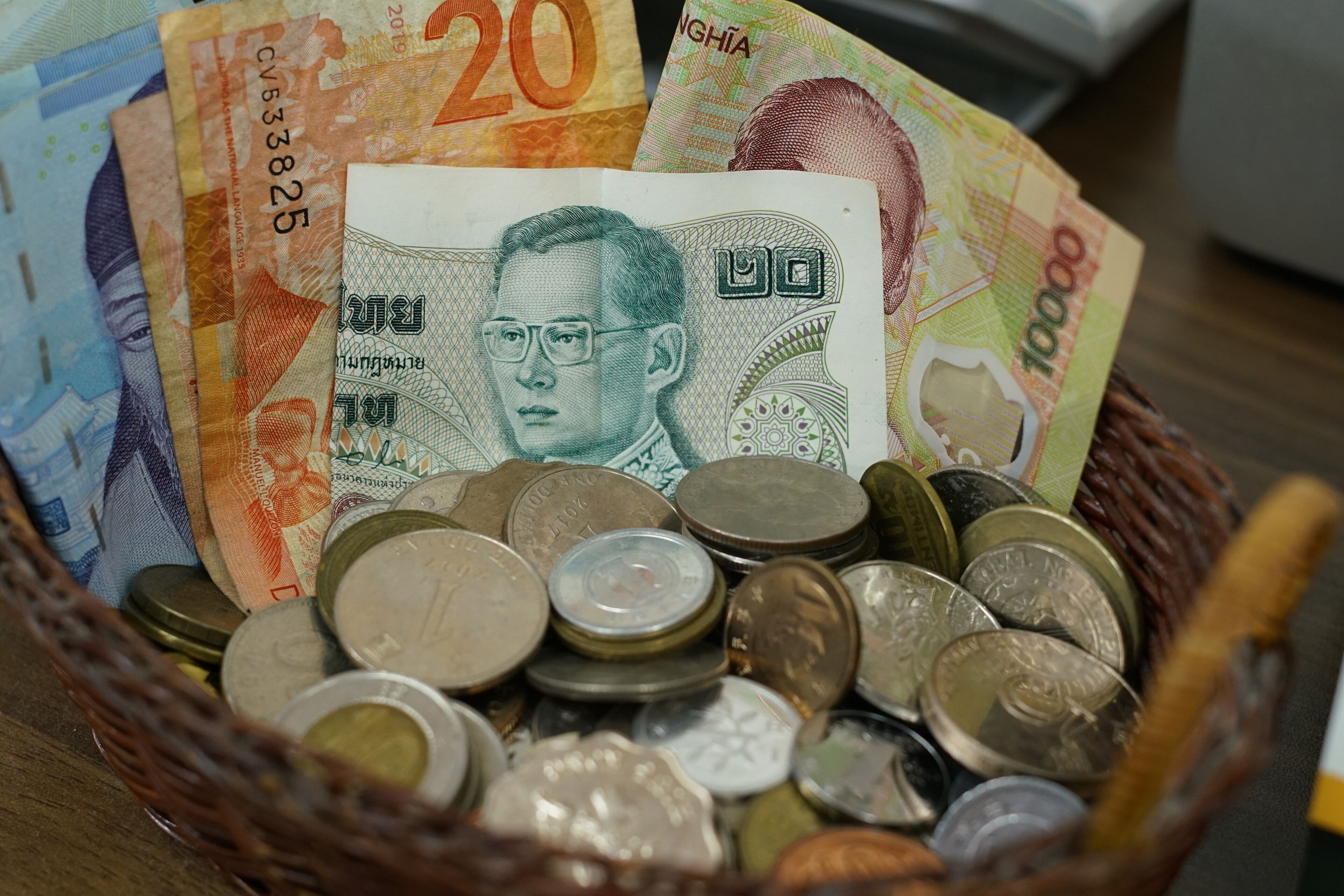 A basket containing various currencies and coins.