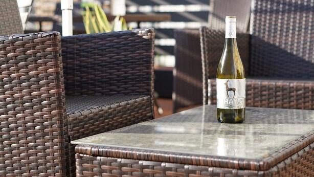Wicker chairs and a table with a bottle of wine. - BONFIRE HOSTEL Osaka (Osaka)