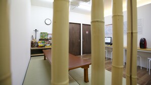 A room with a wooden table, a computer desk, and a map on the wall. - BONFIRE HOSTEL Osaka (Osaka)