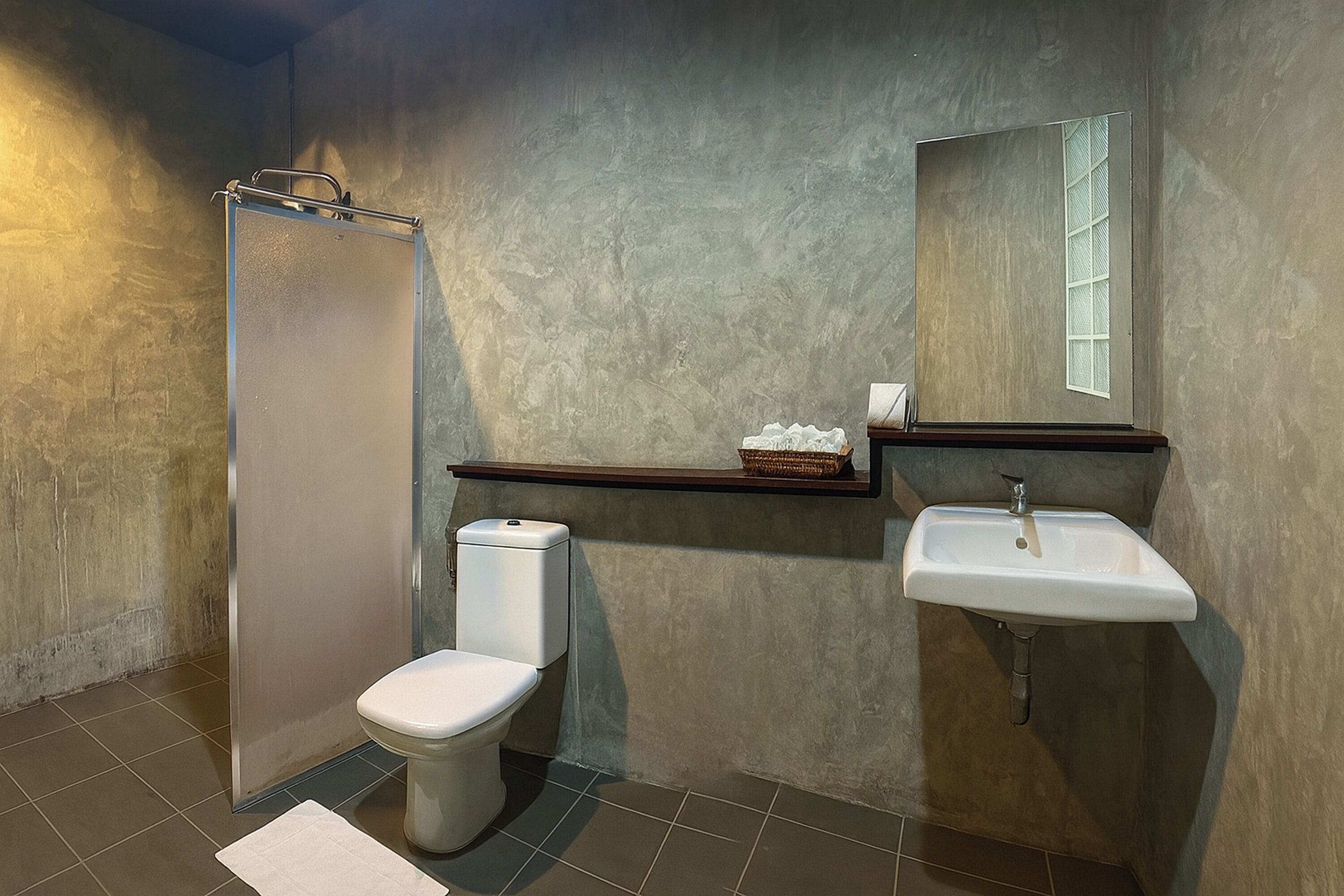 Un baño con ducha, inodoro, lavabo y espejo.