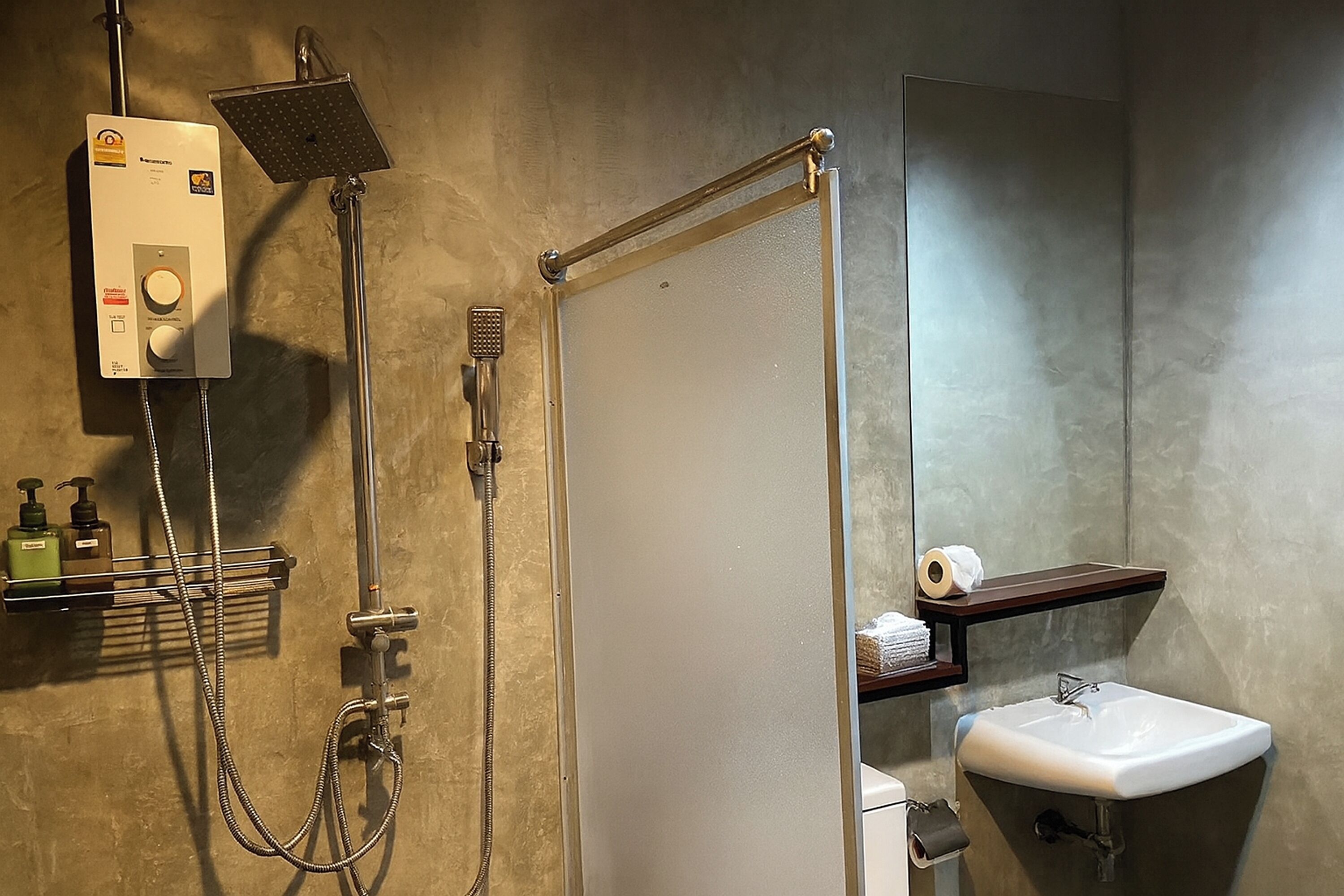 A bathroom with a shower, a toilet, a sink, and a towel rack.