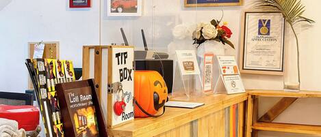 A reception desk with a sign that reads 'TIP BOX' and a decorative pumpkin.