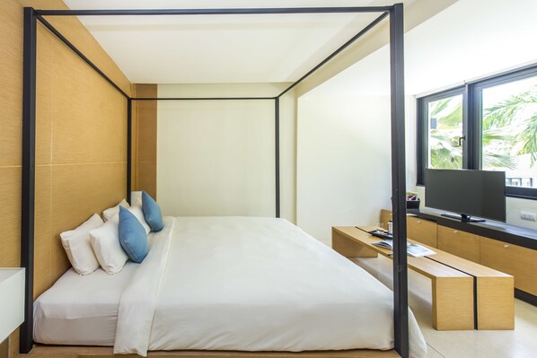 A modern hotel room with a bed, a desk, a TV, and a window with a view of palm trees.