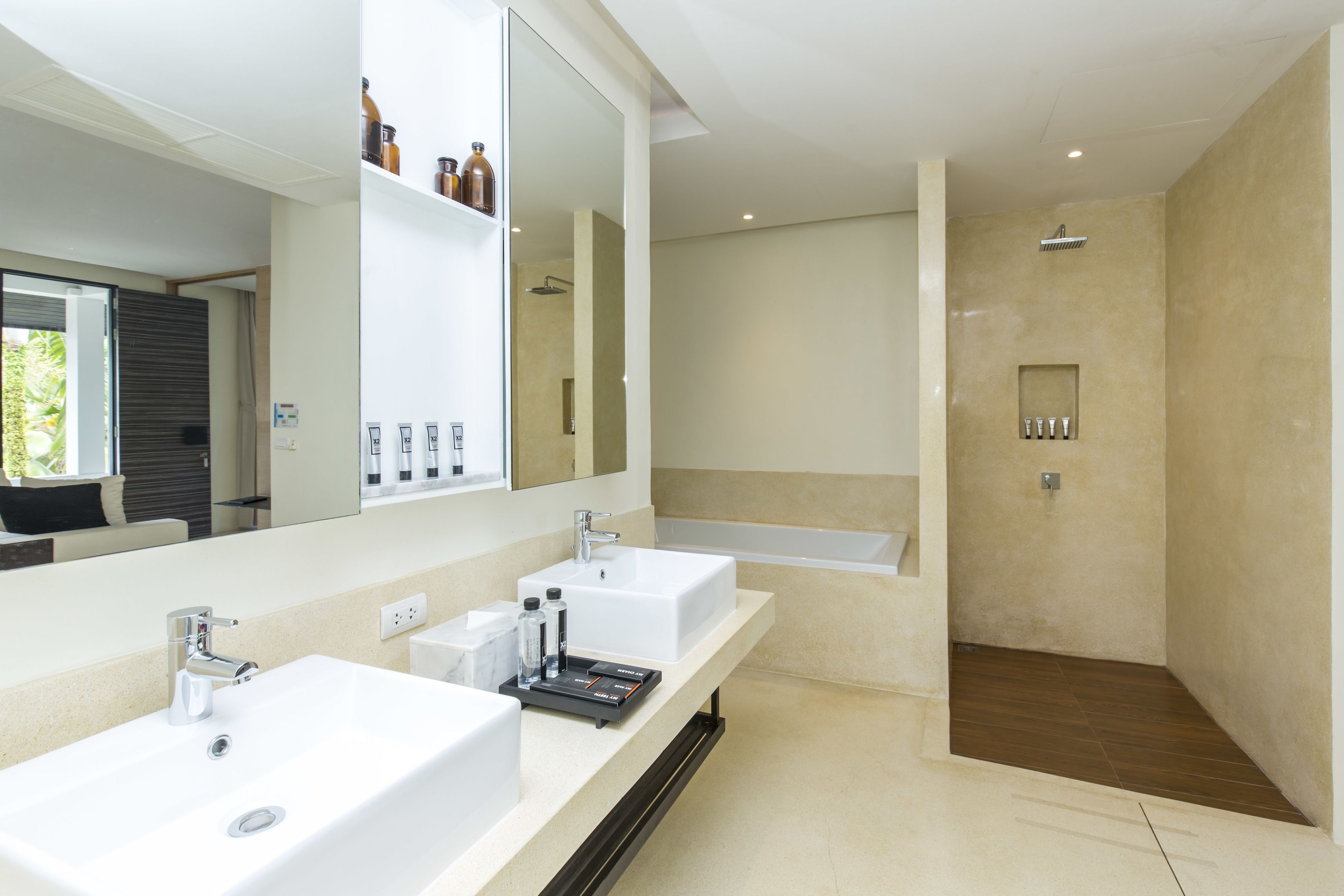 Un baño moderno con dos lavamanos, un espejo grande y una zona de ducha separada.