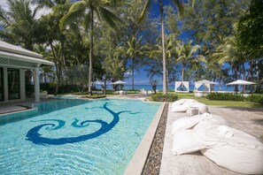 A swimming pool with a blue spiral design, surrounded by palm trees and beach umbrellas. - The Anda Mani Khaolak Beachfront Villas (Thai Mueang)