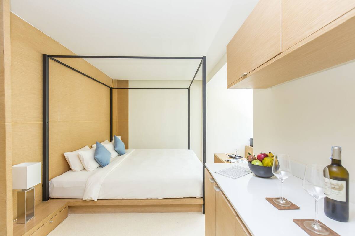 Un dormitorio moderno con cama, mesita de noche y frutero.