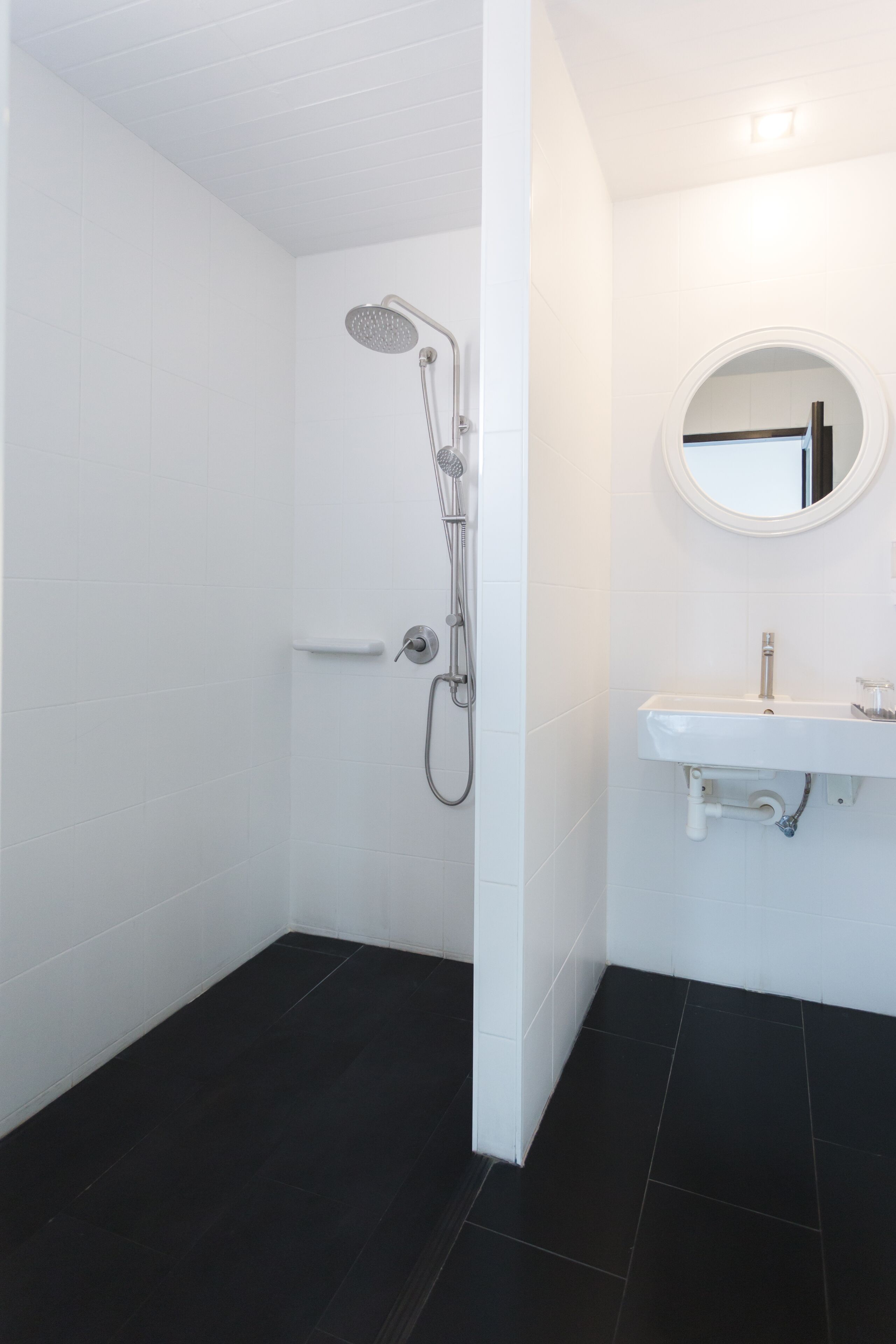 A bathroom with a shower, a sink, and a mirror.