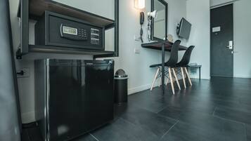 A modern kitchen with a built-in refrigerator, a coffee machine, and a trash bin.