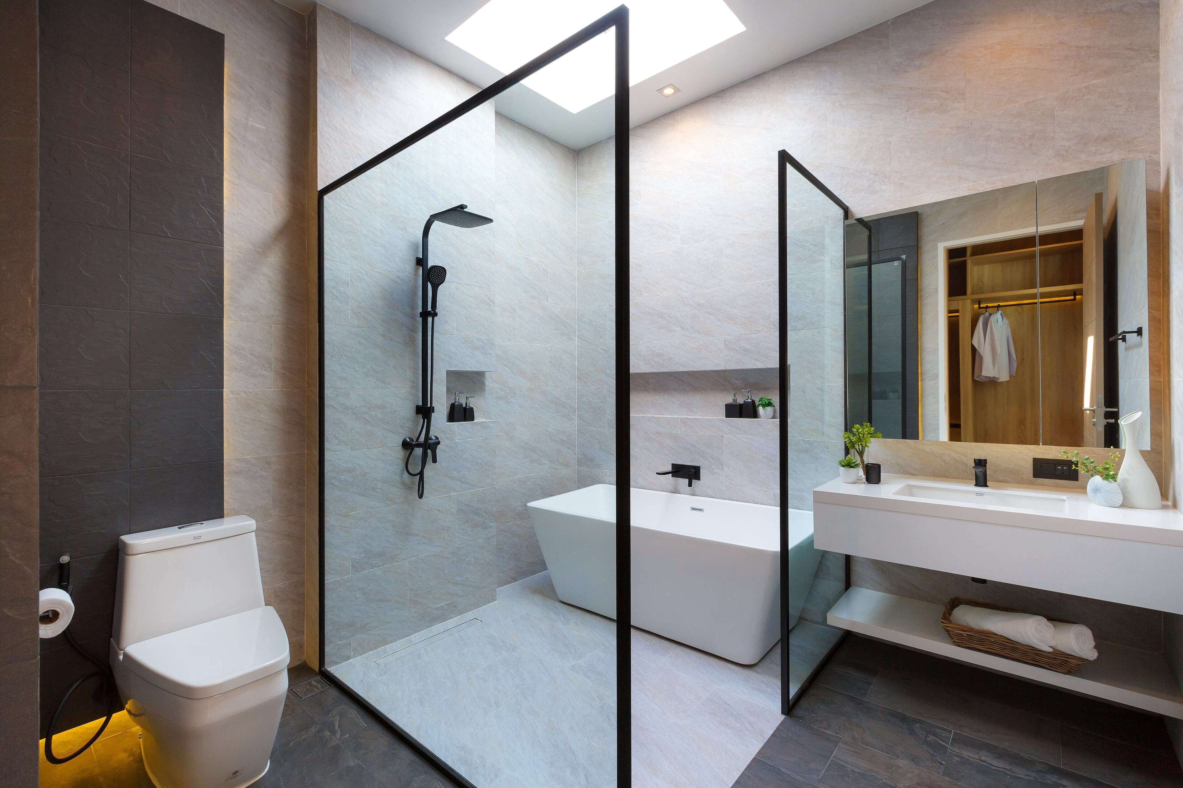 A modern bathroom with a glass-enclosed shower, a freestanding bathtub, and a vanity with a mirror.