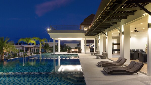 Alberca al aire libre y camastros