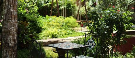 An outdoor patio area with a wooden deck, metal chairs, and a table.