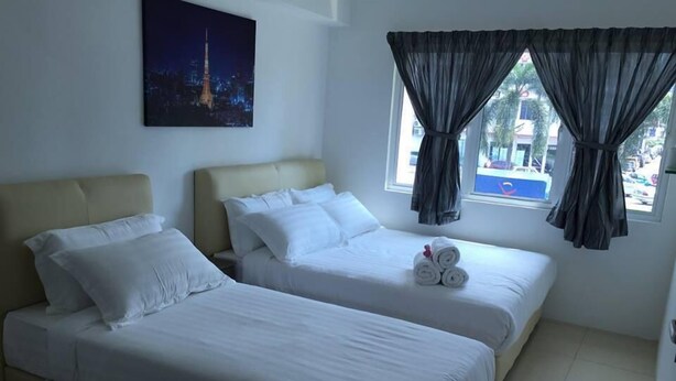 Een hotelkamer met twee bedden, een schilderij van een nachtzicht en een raam met gordijnen.