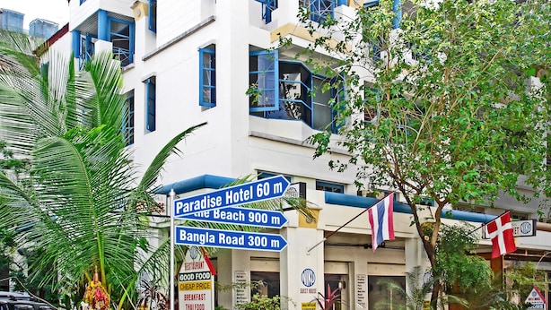 A hotel with a sign indicating Paradise Hotel 60m, Bangla Road 300m, and the beach 900m away.