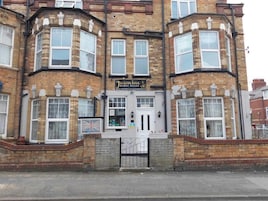 Un edificio en esquina con un letrero que dice 'Jasmine Guest House'.