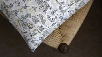 A bed with a patterned bedspread featuring various architectural and cultural illustrations.