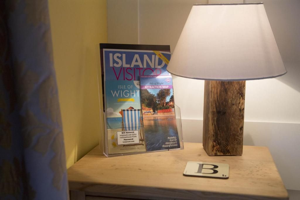 A magazine titled 'Island Visitor' on a wooden nightstand with a lamp.