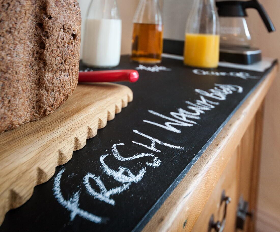 A wooden counter with a chalkboard displaying the words "fresh" and "drink."