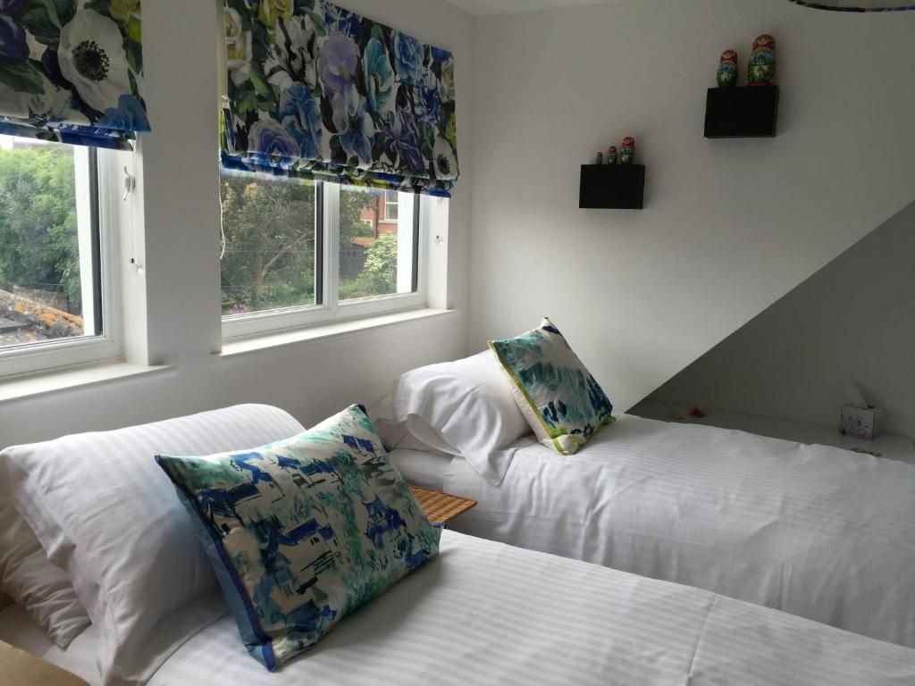 Ein Schlafzimmer mit zwei Betten, einem Fenster mit Blick und einer kleinen Ablage mit Flaschen.