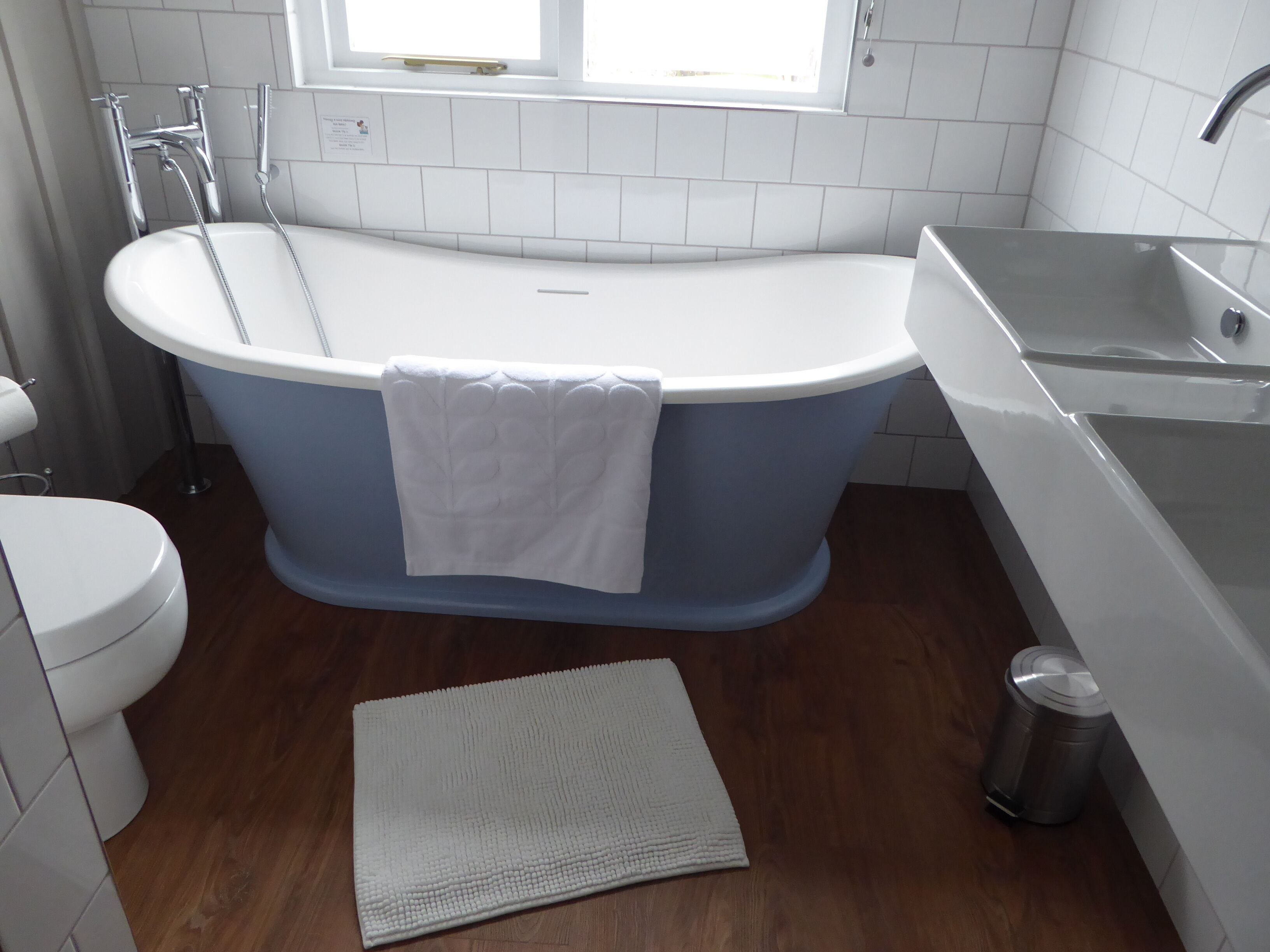 A modern bathroom with a freestanding bathtub, a toilet, and a sink.