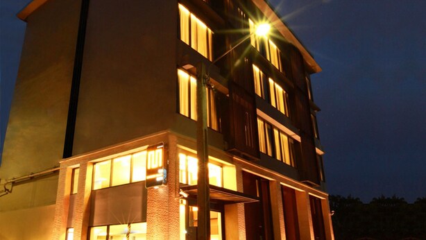Um hotel com vários andares, janelas iluminadas e uma entrada bem iluminada.