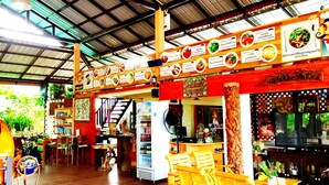 A restaurant with wooden furniture, a high ceiling, and a menu board displaying various dishes. - Raisongrao Resort (Khao Kho)