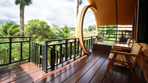 A wooden deck with a curved railing, a wooden bench, and a view of lush greenery and distant hills. - Raisongrao Resort (Khao Kho)