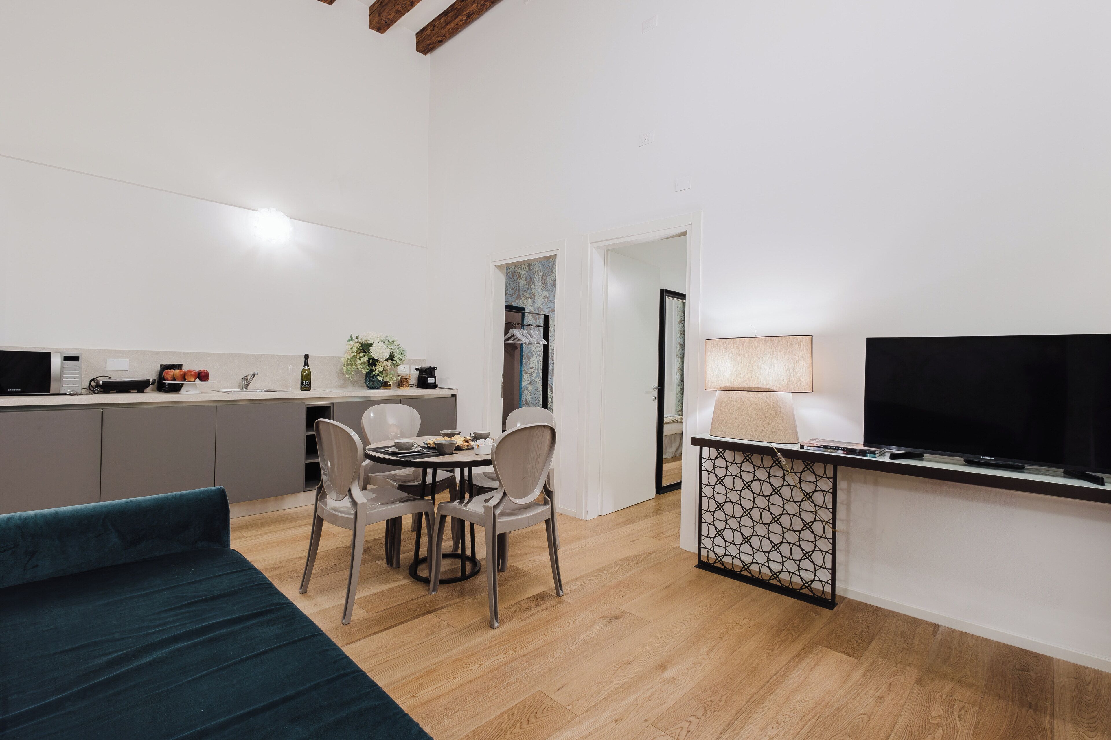 A compact living space with a kitchenette, dining area, and a TV.
