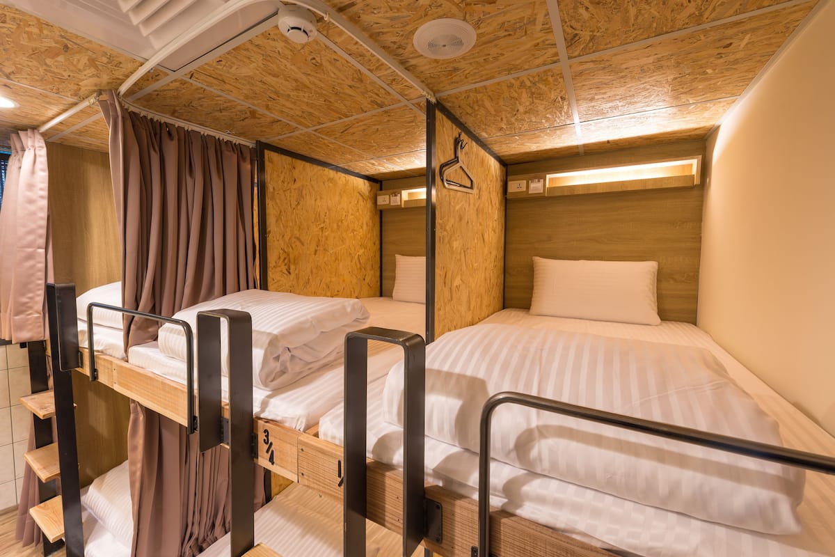 A bunk bed room with wooden walls and a ceiling fan.