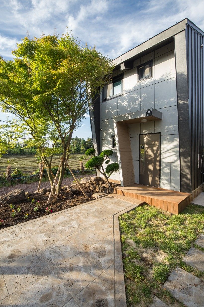 A modern building with a flat roof, a door, and a small window.