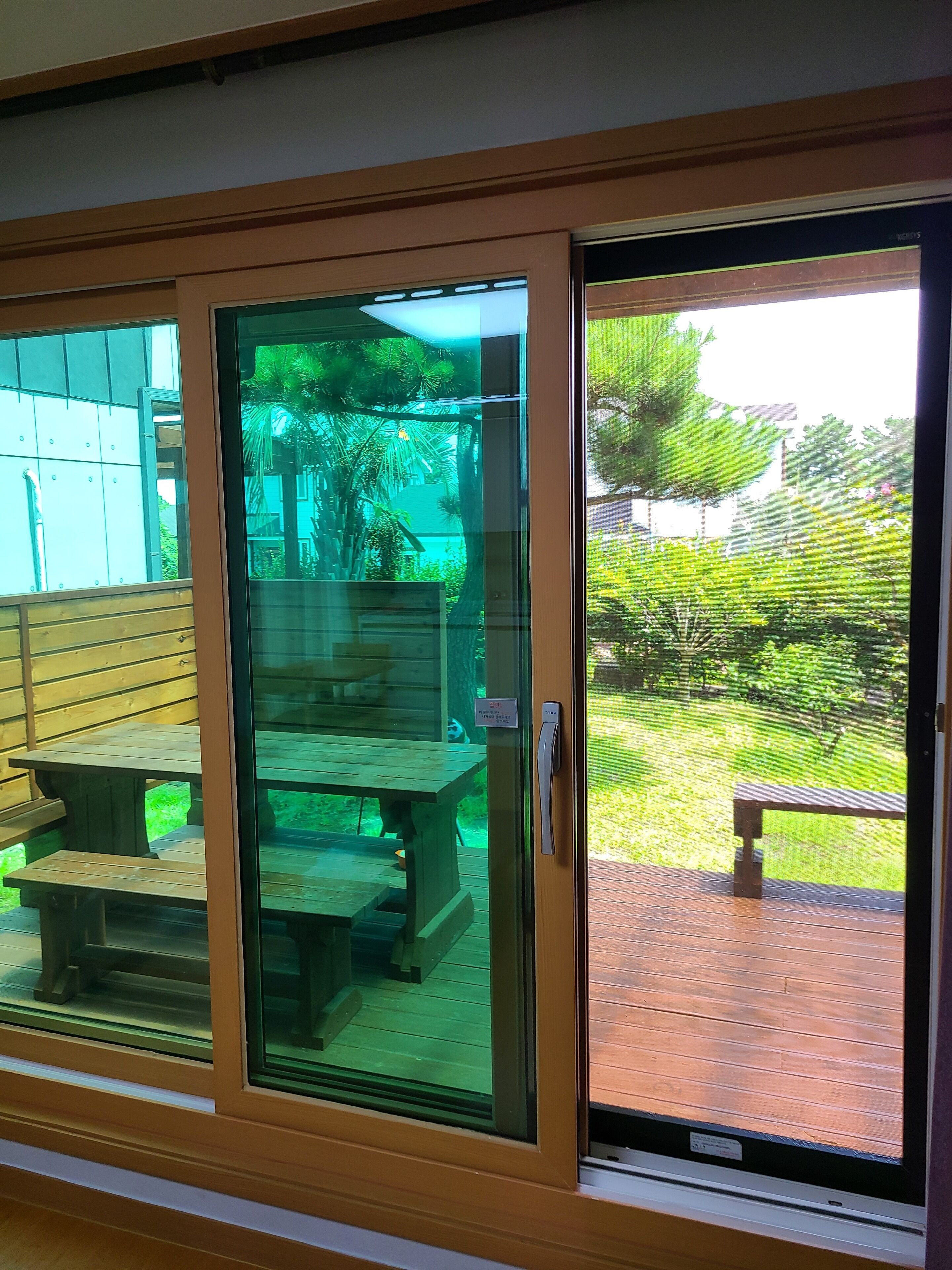 A sliding glass door leading to an outdoor patio area with wooden benches and a table.