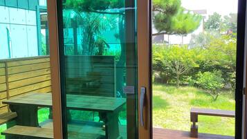 A sliding glass door leading to an outdoor patio area with wooden benches and a table.