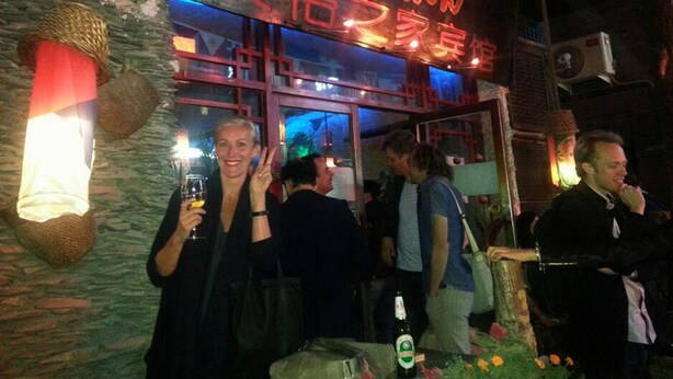 A restaurant with a neon sign, outdoor seating, and a stone facade. - 365 inn - Hostel (Beijing)