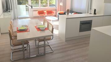 Una cocina moderna con comedor, ventanas amplias y vistas al verdor.