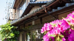 Un bâtiment japonais traditionnel, doté d’une façade en bois et d’une enseigne avec des caractères japonais.