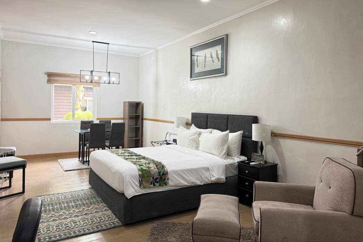 Une chambre d’hôtel moderne équipée d’un grand lit, d’un bureau, d’une chaise et d’une bibliothèque.