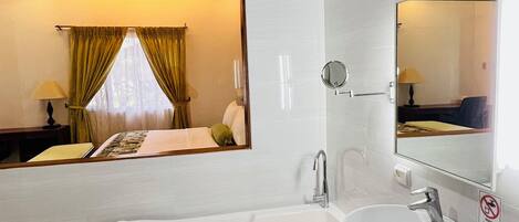 Ein modernes Badezimmer mit einer großen Badewanne, einem runden Waschbecken und einem Spiegel.