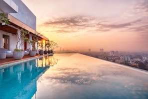 A modern infinity pool with a city view at sunset. - Jetwing Colombo Seven (Colombo)