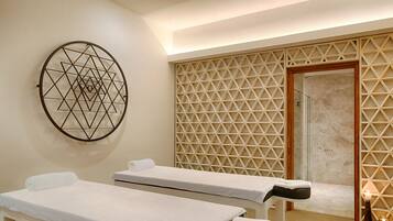 Experience tranquility in this serene spa room with two treatment beds and a geometric design.