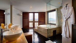 Un baño moderno con un lavamanos grande, una bañera y una ducha con mampara de vidrio.